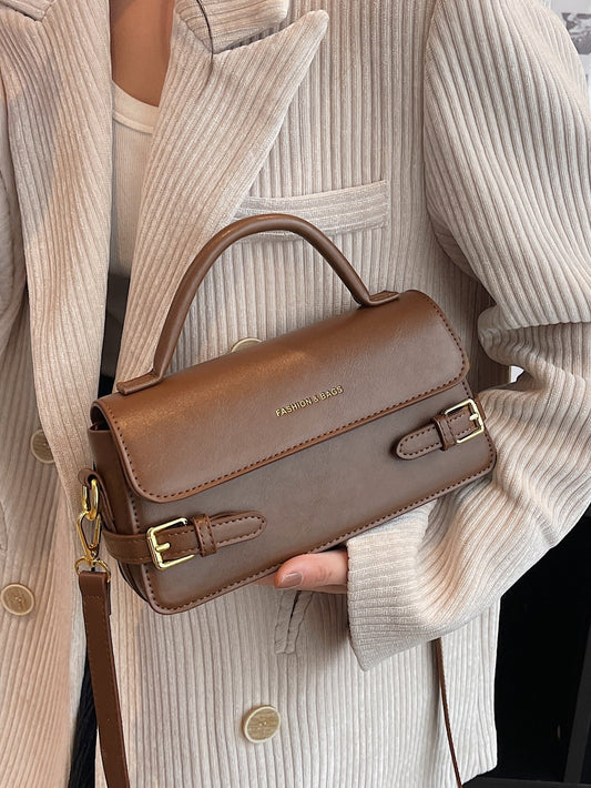 BOLSO CUADRADO CON SOLAPA DECORATIVA Y HEBILLA CON LETRAS EN RELIEVE